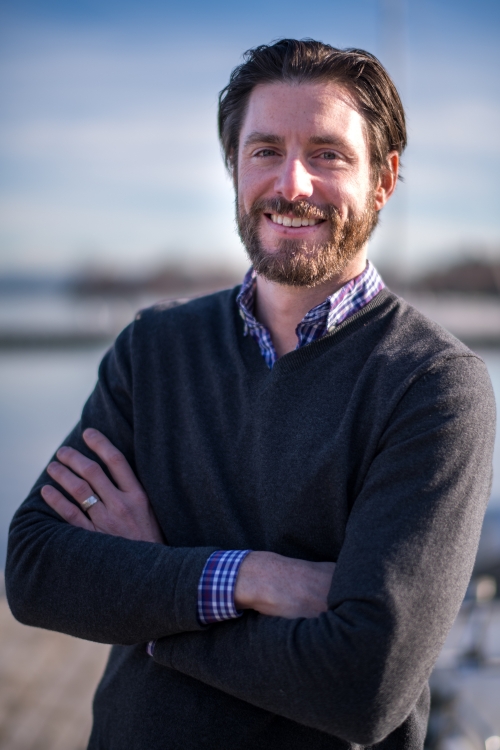 Portrait of man with beard near water. 